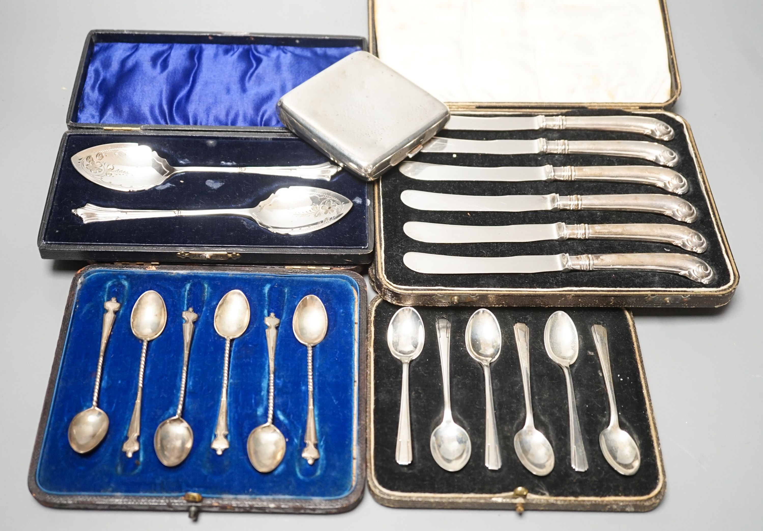 Four cased sets of cutlery including silver teaspoons and pair of silver preserve spoons and a silver cigarette case.